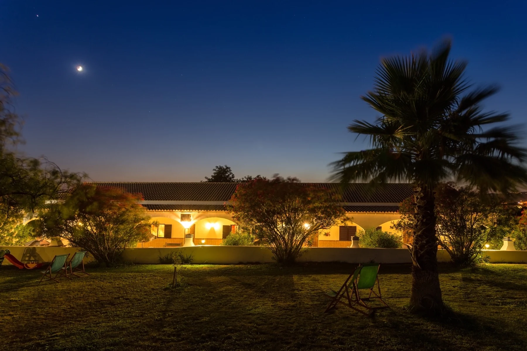 Les villas et les palmiers illuminés dans le jardin le soir